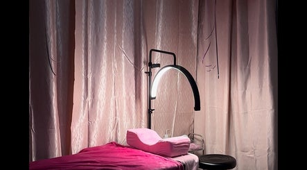 Soothing treatment room at Nyla Beauty & Fashion, Paramaribo, SR with soft lighting and a plush massage bed.