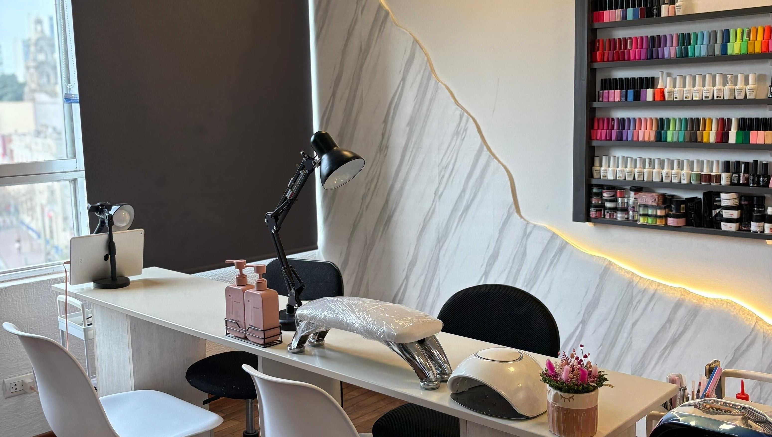 Mesa de manicura en Social Nails Club, Lima, Callao, PE, con estilo moderno y colores vibrantes de esmaltes.