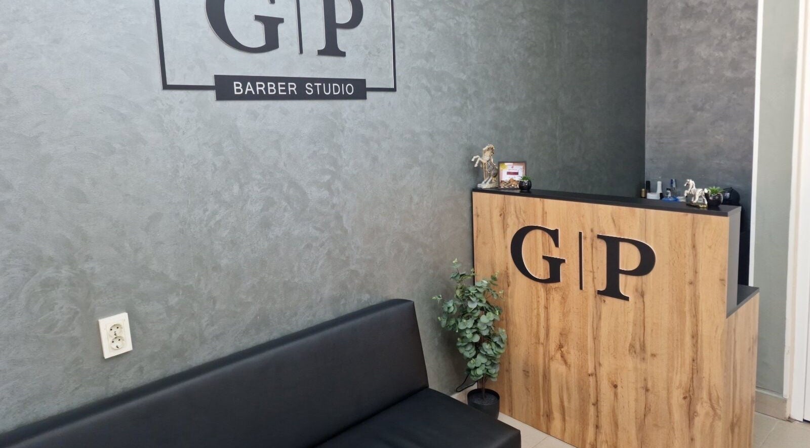 Reception area at GP Barber Studio in Harmanli, Haskovo, BG featuring modern decor and black seating.