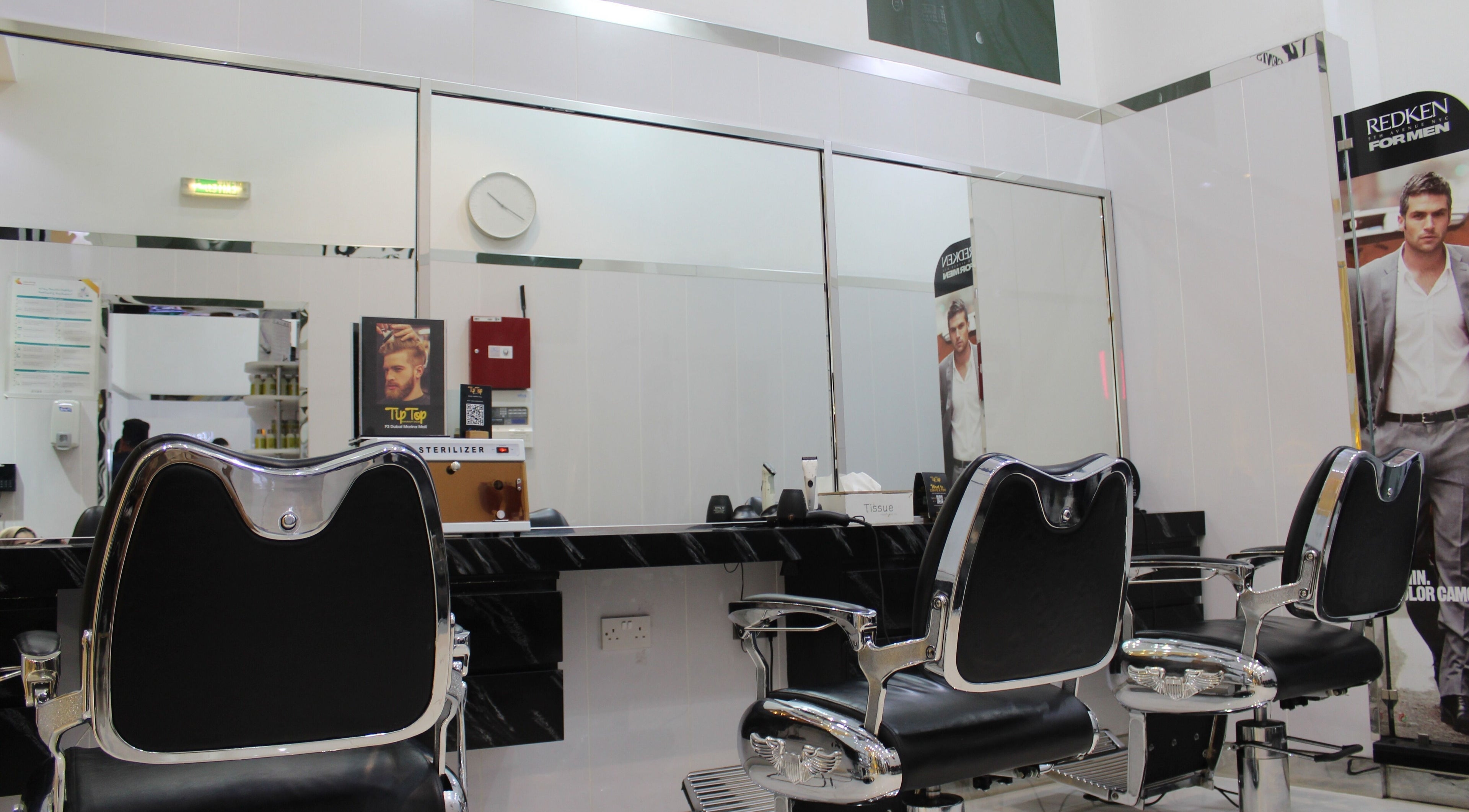 Sleek interior of Tip Top Star Gents Salon in Dubai, Dubai, AE, featuring stylish chairs and large mirrors.
