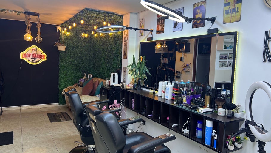 Interior moderno de Lady Barber La Chama en Santiago De Surco, Provincia De Lima, PE con sillas elegantes y luces cálidas.