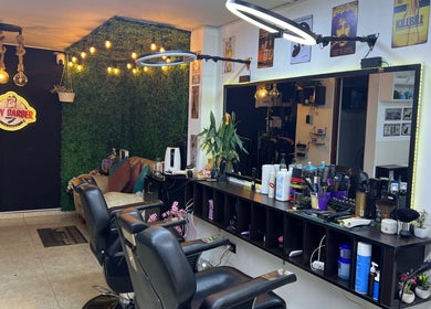 Interior moderno de Lady Barber La Chama en Santiago De Surco, Provincia De Lima, PE con sillas elegantes y luces cálidas.