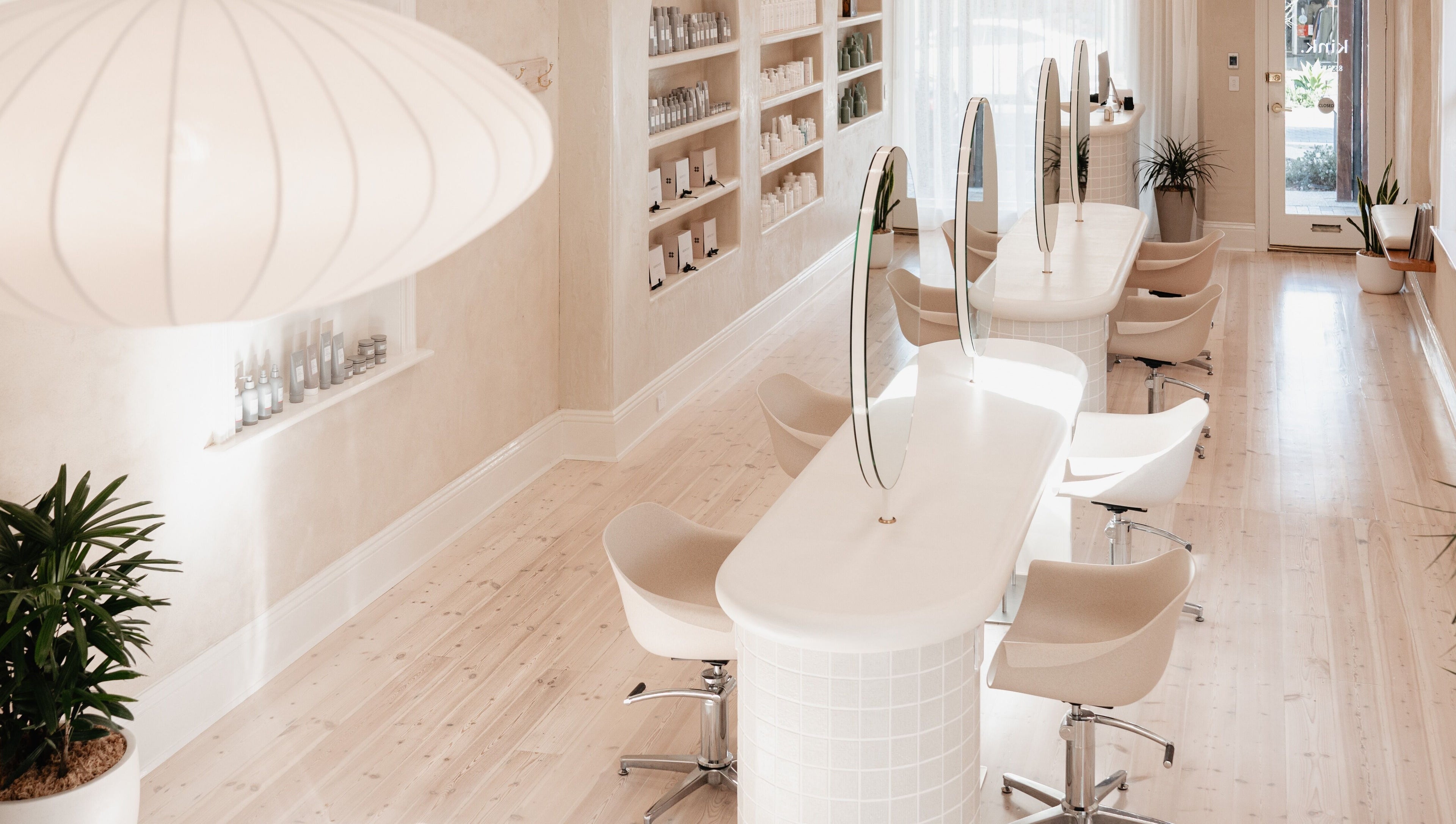 Elegant beauty salon interior at Kink, Victor Harbor, South Australia, AU with chic white design and seating.