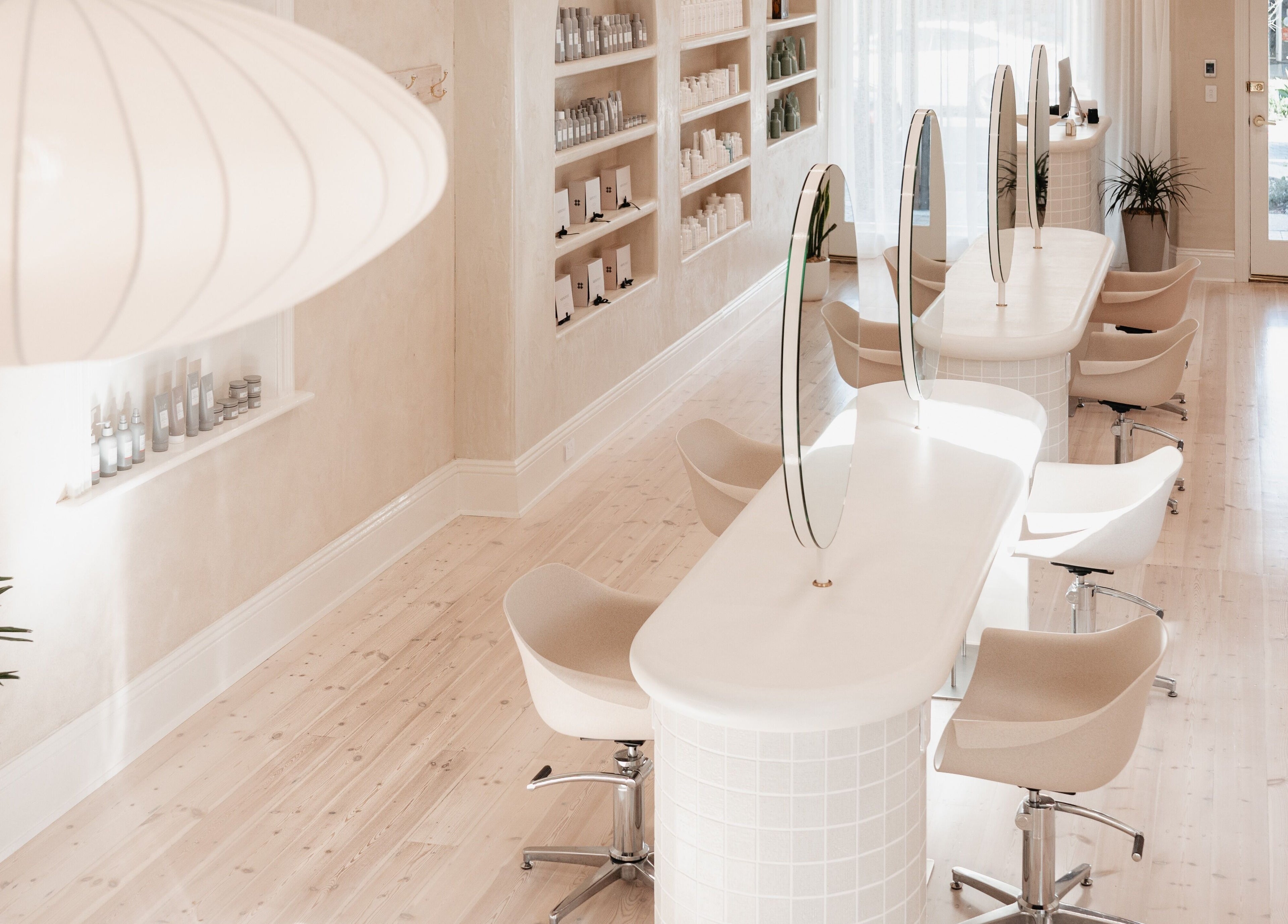 Elegant beauty salon interior at Kink, Victor Harbor, South Australia, AU with chic white design and seating.