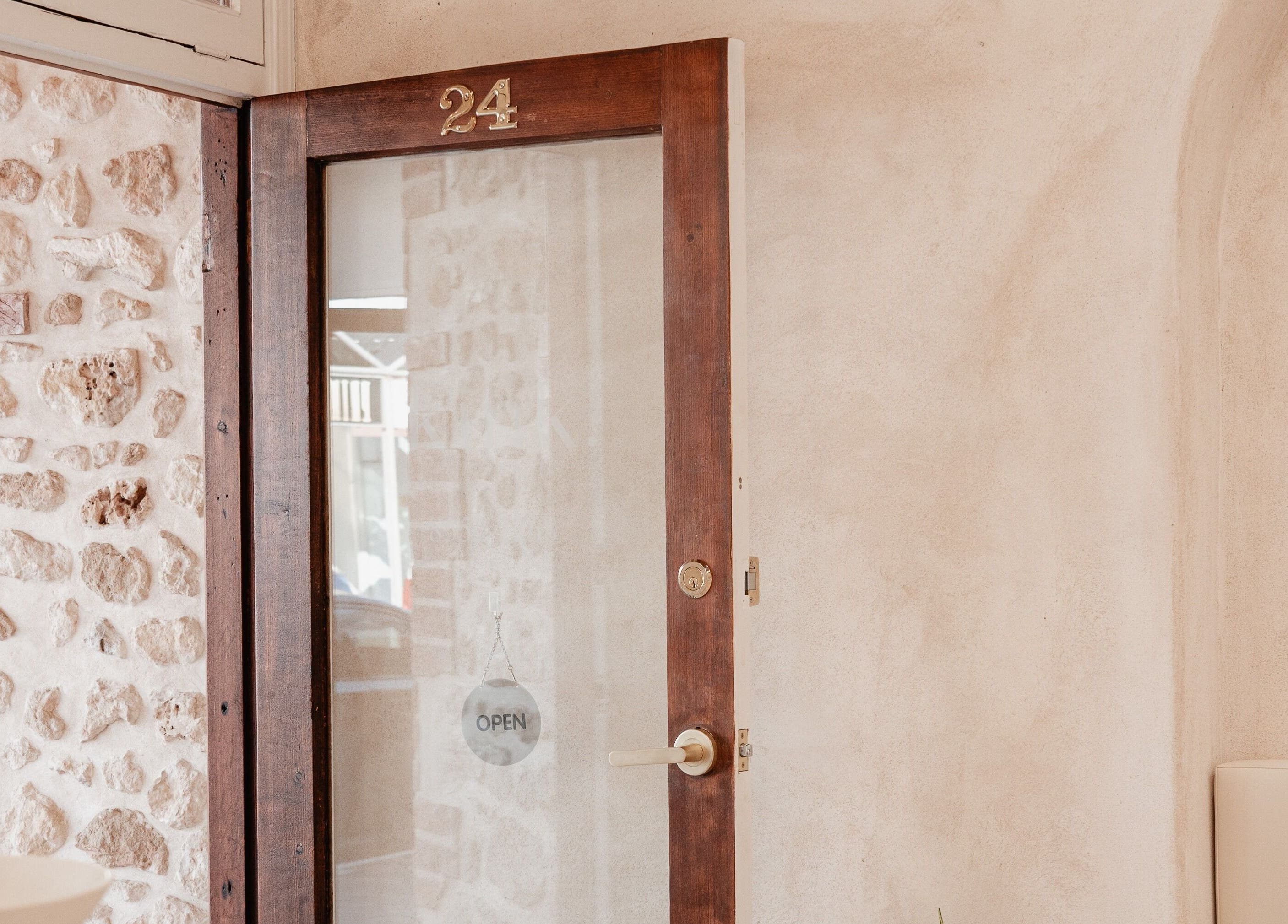 Rustic wooden door at Kink, Victor Harbor, South Australia, AU showcasing inviting charm and open sign.