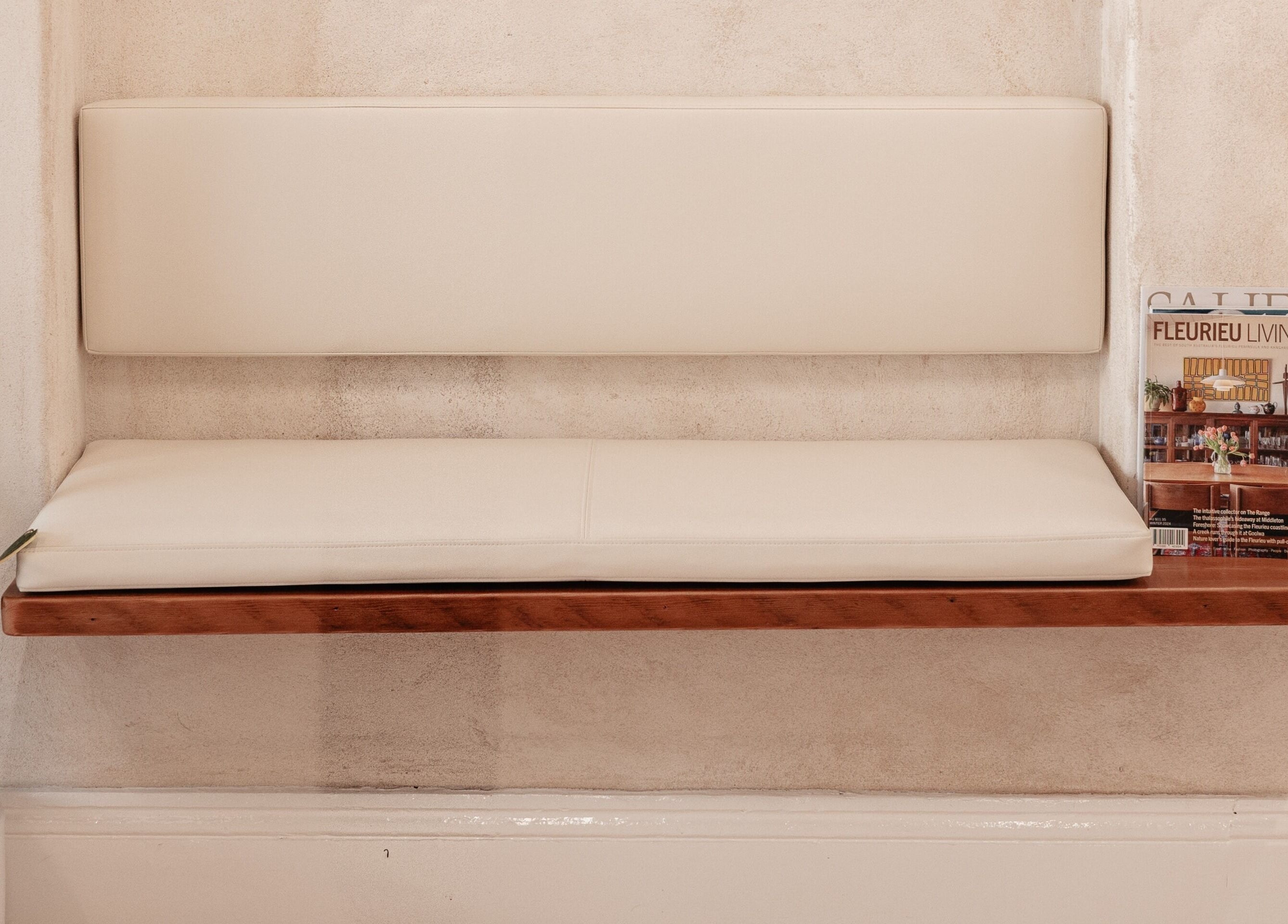 Minimalist seating area at Kink in Victor Harbor, South Australia, AU featuring a cushioned bench and potted plant.