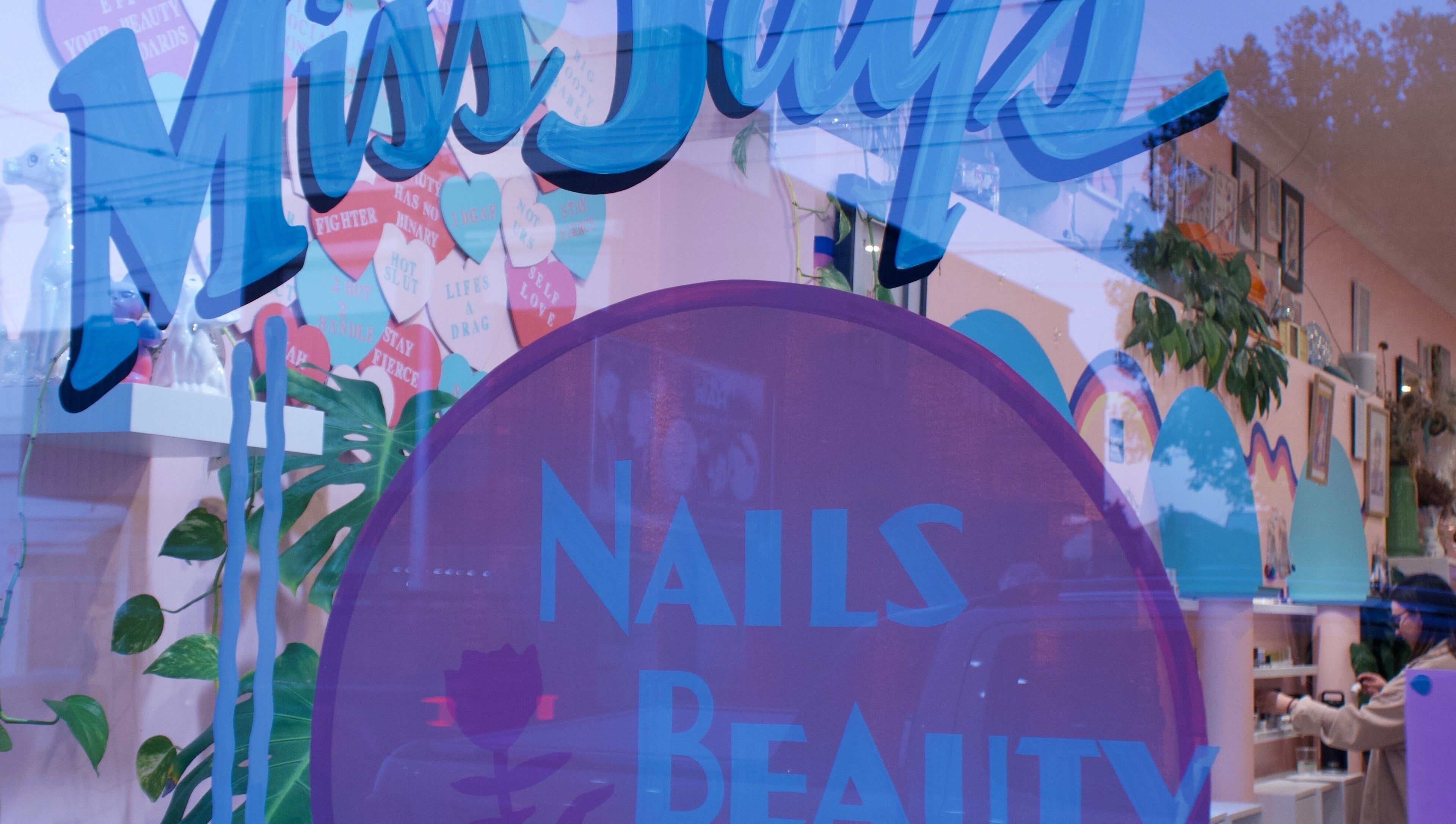 Exterior shot of Junoxwatt, Melbourne, Victoria, AU, showcasing colorful nail and beauty signage.