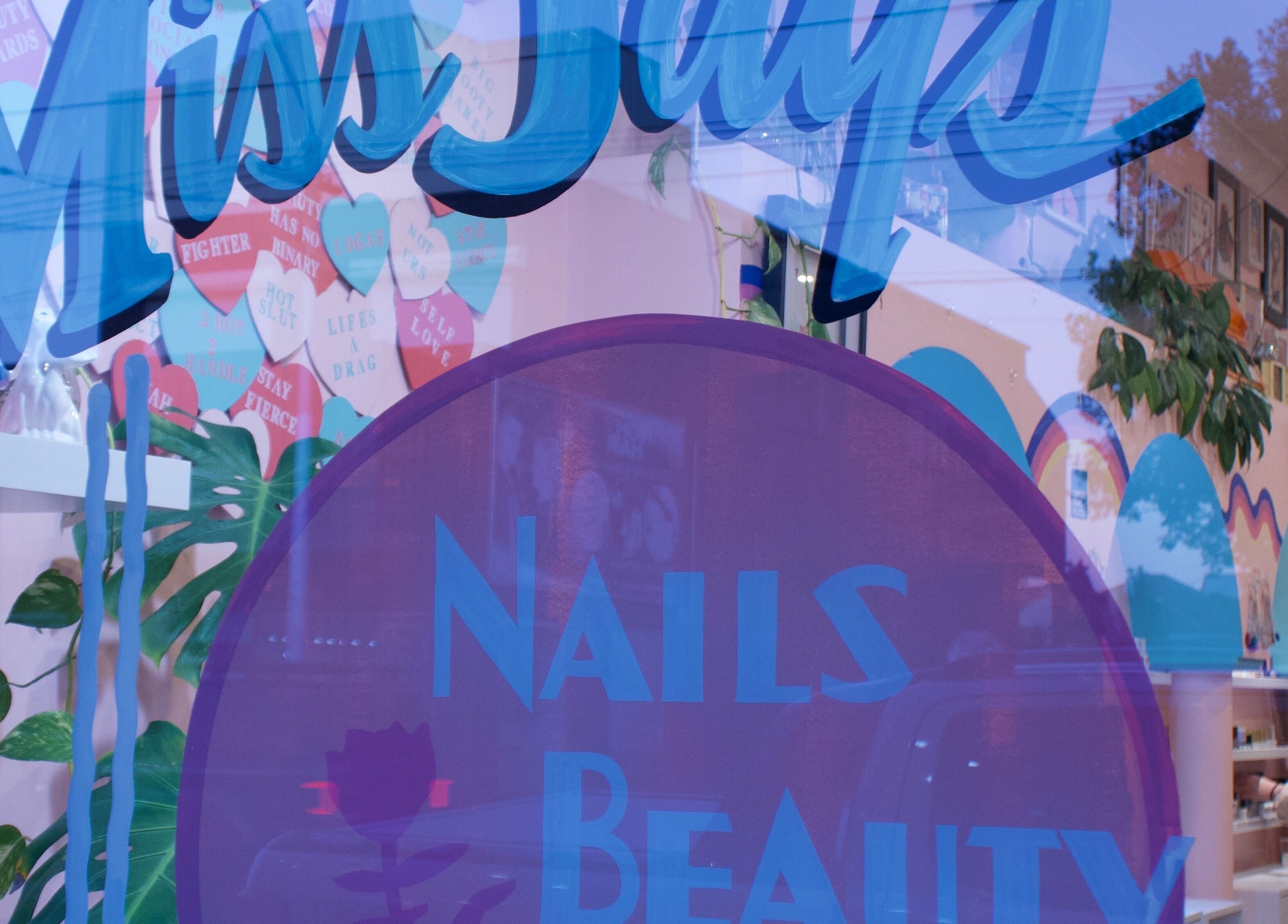 Exterior shot of Junoxwatt, Melbourne, Victoria, AU, showcasing colorful nail and beauty signage.