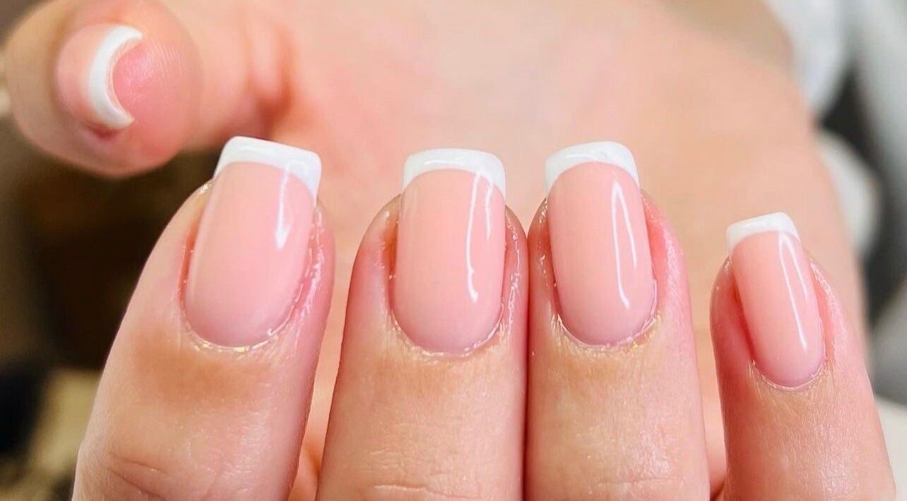 French manicure at Cure in Appleby, NZ, showcasing glossy pink nails with white tips.