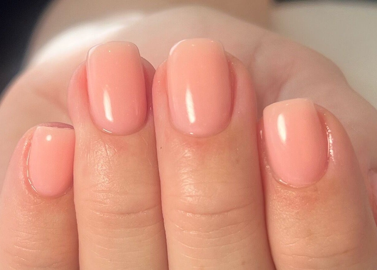 Glossy, well-manicured nails at Cure in Appleby, NZ, showcasing elegant nude polish.