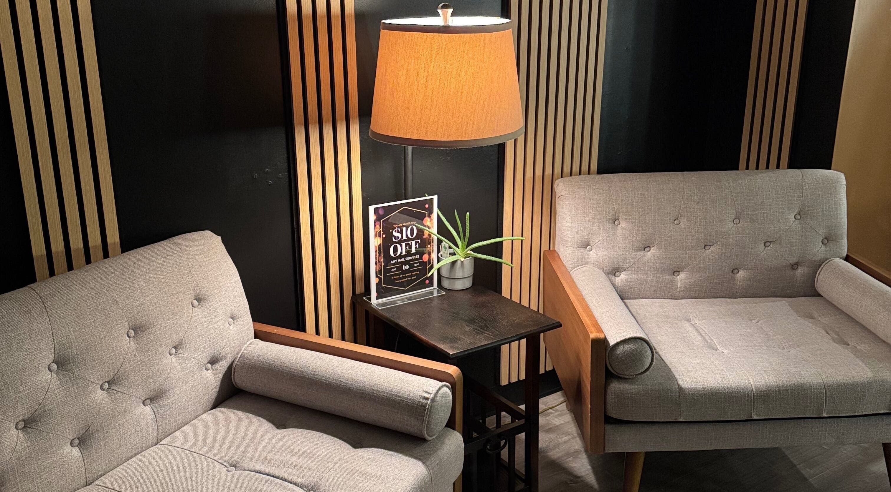 Stylish waiting area at Lamour Nails, Orem, Utah, US, featuring modern chairs and a warm lamp.
