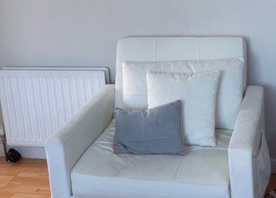Comfortable white armchair with cushions at TY Beauty, Portadown, Northern Ireland, GB.