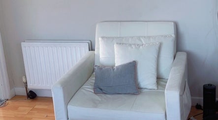 Comfortable white armchair with cushions at TY Beauty, Portadown, Northern Ireland, GB.
