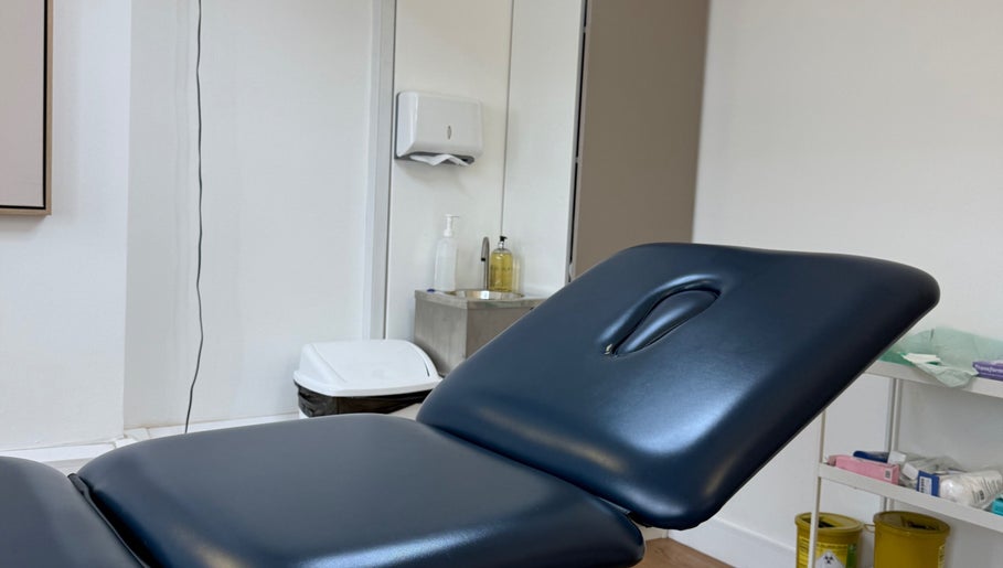 Comfortable treatment room at Aesthetic in Manchester, England, GB featuring a sleek therapy bed.
