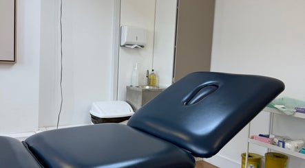 Comfortable treatment room at Aesthetic in Manchester, England, GB featuring a sleek therapy bed.