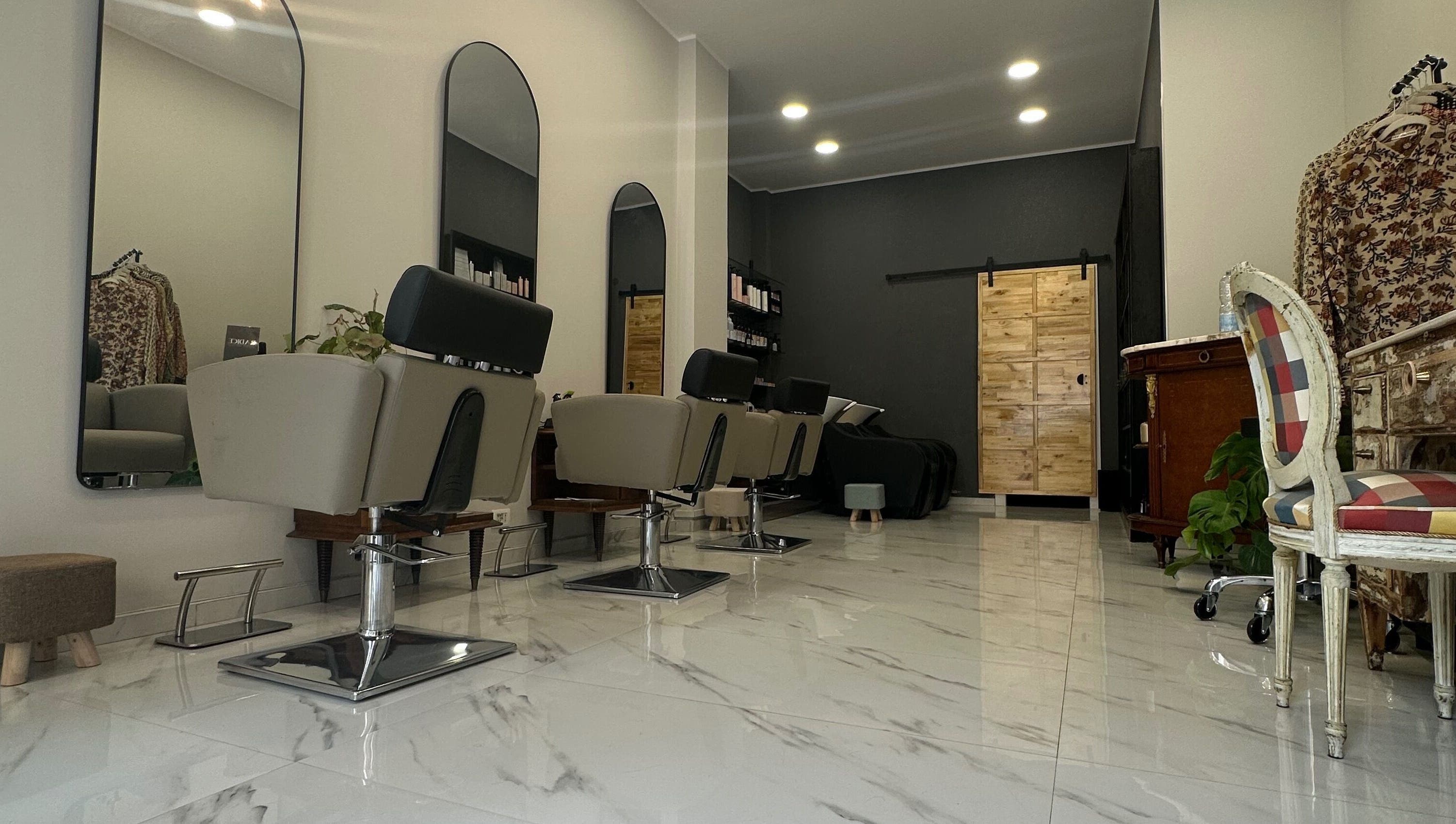 Interno elegante del Radice Hair Salon a Roma, Lazio, IT con poltrone di design e pavimento lucido.