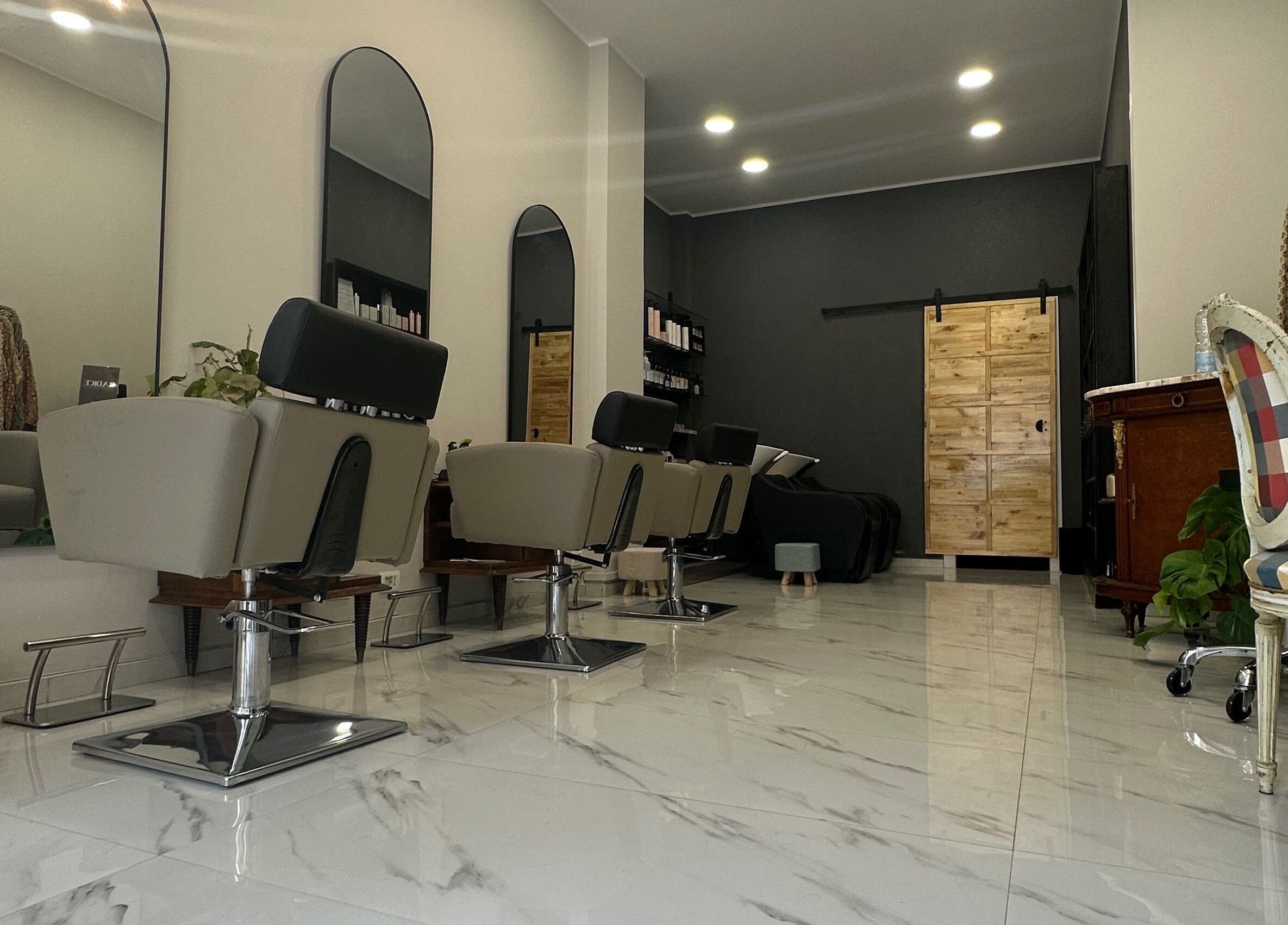 Interno elegante del Radice Hair Salon a Roma, Lazio, IT con poltrone di design e pavimento lucido.