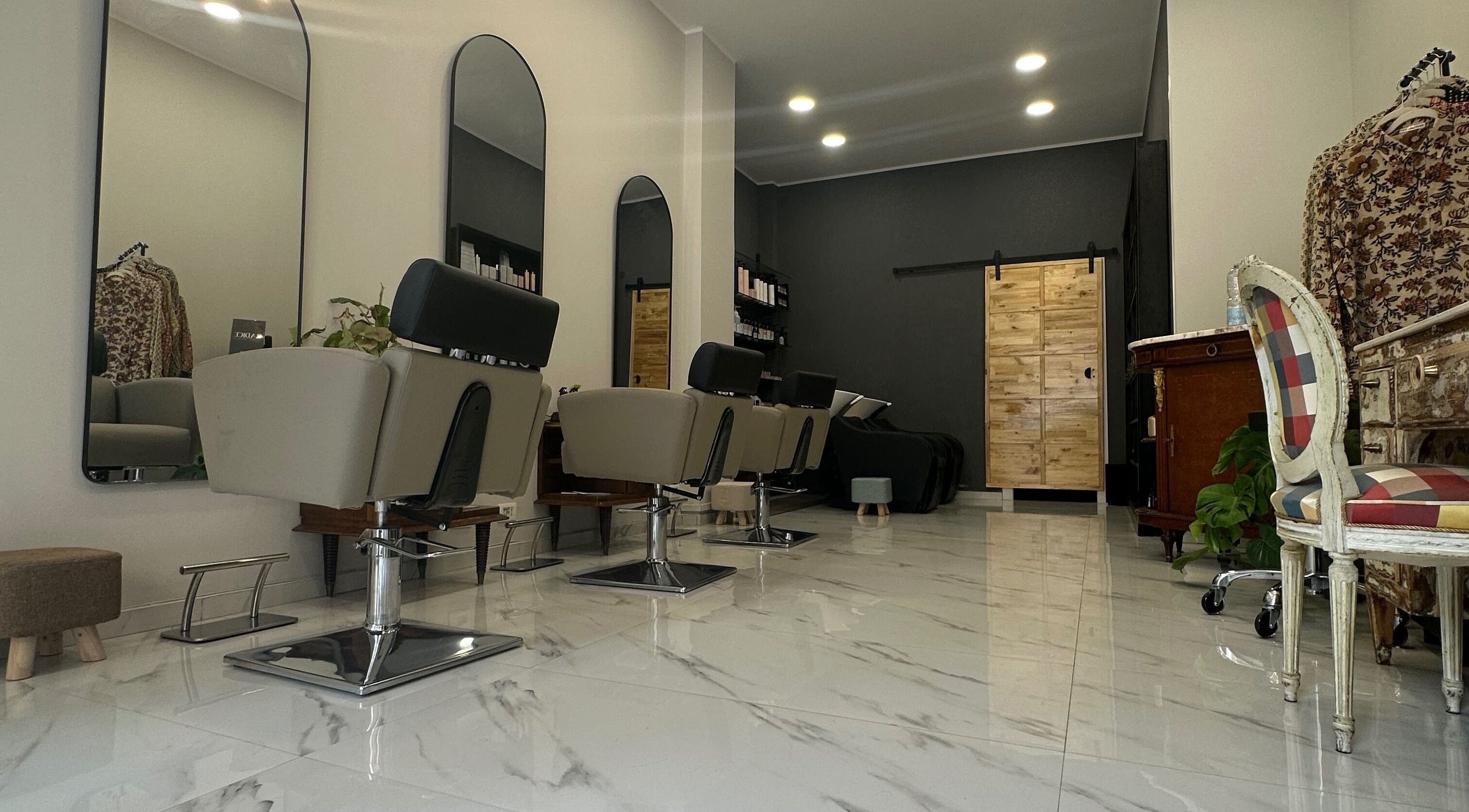 Interno elegante del Radice Hair Salon a Roma, Lazio, IT con poltrone di design e pavimento lucido.