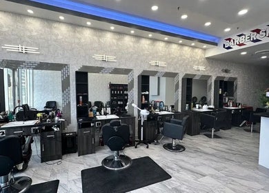 Modern barber area at EKI ROYAL BEAUTY LOUNGE, Edmonton, Alberta, CA with stylish chairs and mirrors.