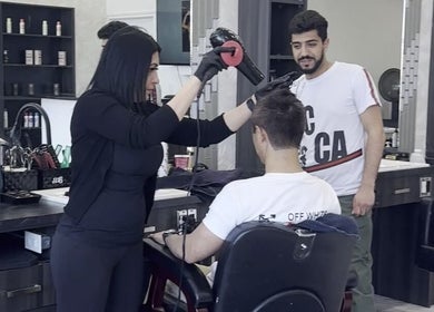 Stylist at EKI ROYAL BEAUTY LOUNGE, Edmonton, Alberta, CA, providing a haircut service.