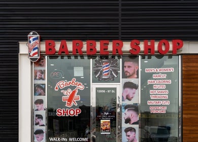 Front of EKI ROYAL BEAUTY LOUNGE, a barber shop in Edmonton, Alberta, CA. Large sign and glass door with hair styling images.