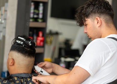 Stylist at EKI ROYAL BEAUTY LOUNGE in Edmonton, Alberta, CA, giving a precise haircut.