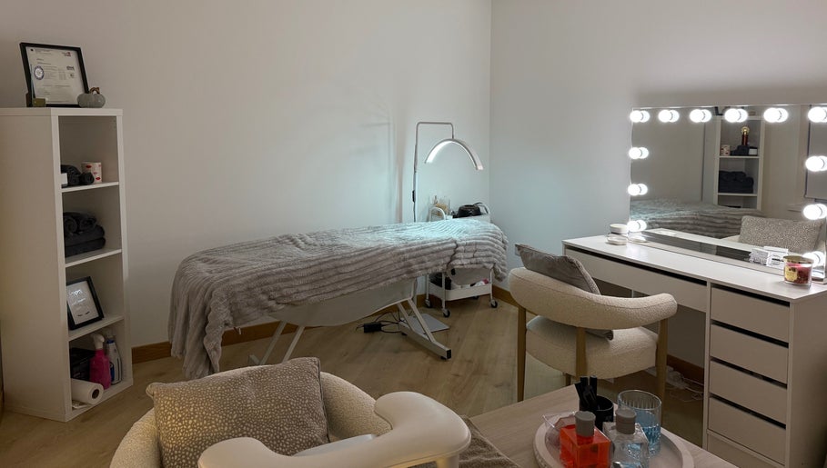 Therapy room at Belle Beauty, Maud, Scotland, GB, featuring a treatment bed and illuminated vanity mirror.