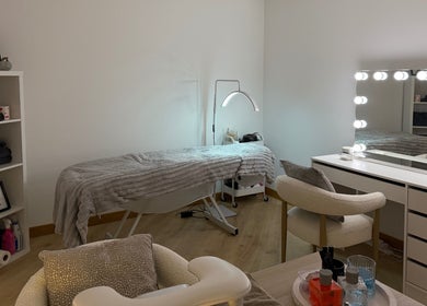 Therapy room at Belle Beauty, Maud, Scotland, GB, featuring a treatment bed and illuminated vanity mirror.