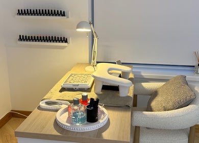 Elegant manicure station at Belle Beauty, Maud, Scotland, GB, featuring nail polishes and comfy seating.