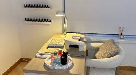 Elegant manicure station at Belle Beauty, Maud, Scotland, GB, featuring nail polishes and comfy seating.