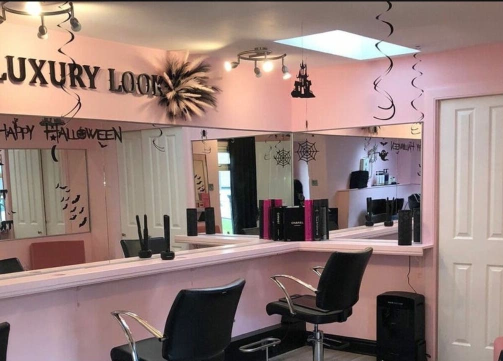 Bright pink-themed LashMuse salon in Tweedbank, Scotland, GB with stylish seating and Halloween decor.