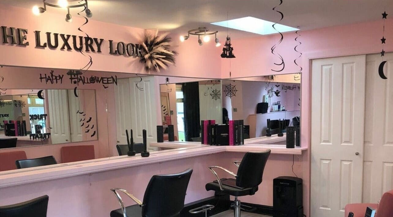 Bright pink-themed LashMuse salon in Tweedbank, Scotland, GB with stylish seating and Halloween decor.