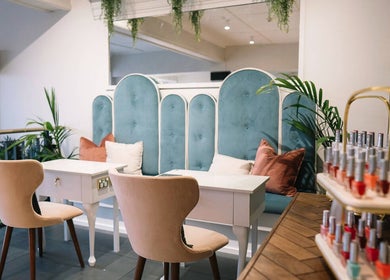 Chic nail salon setup at Alchemy & I, Palmerston North, Manawatū-whanganui Region, NZ, featuring plush seating and vibrant decor.