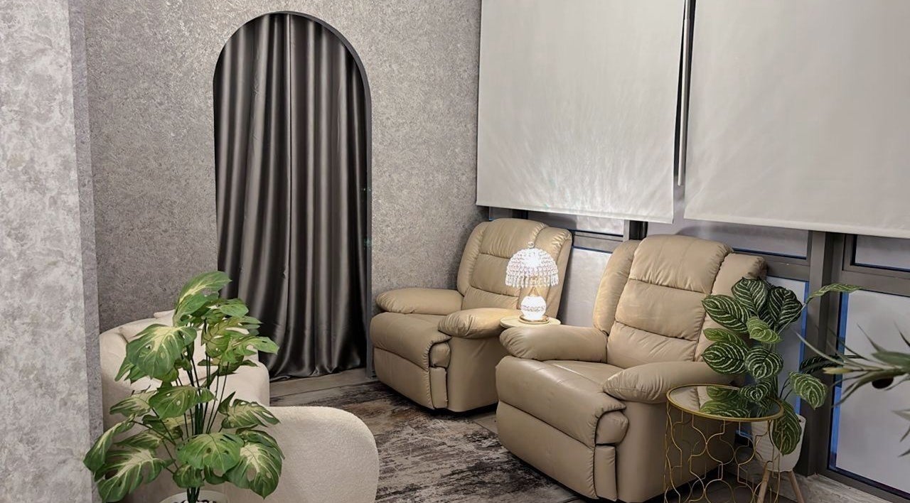 Cozy lounge at Lashthetic8Bar in Kuala Lumpur with plush chairs and lush plants.