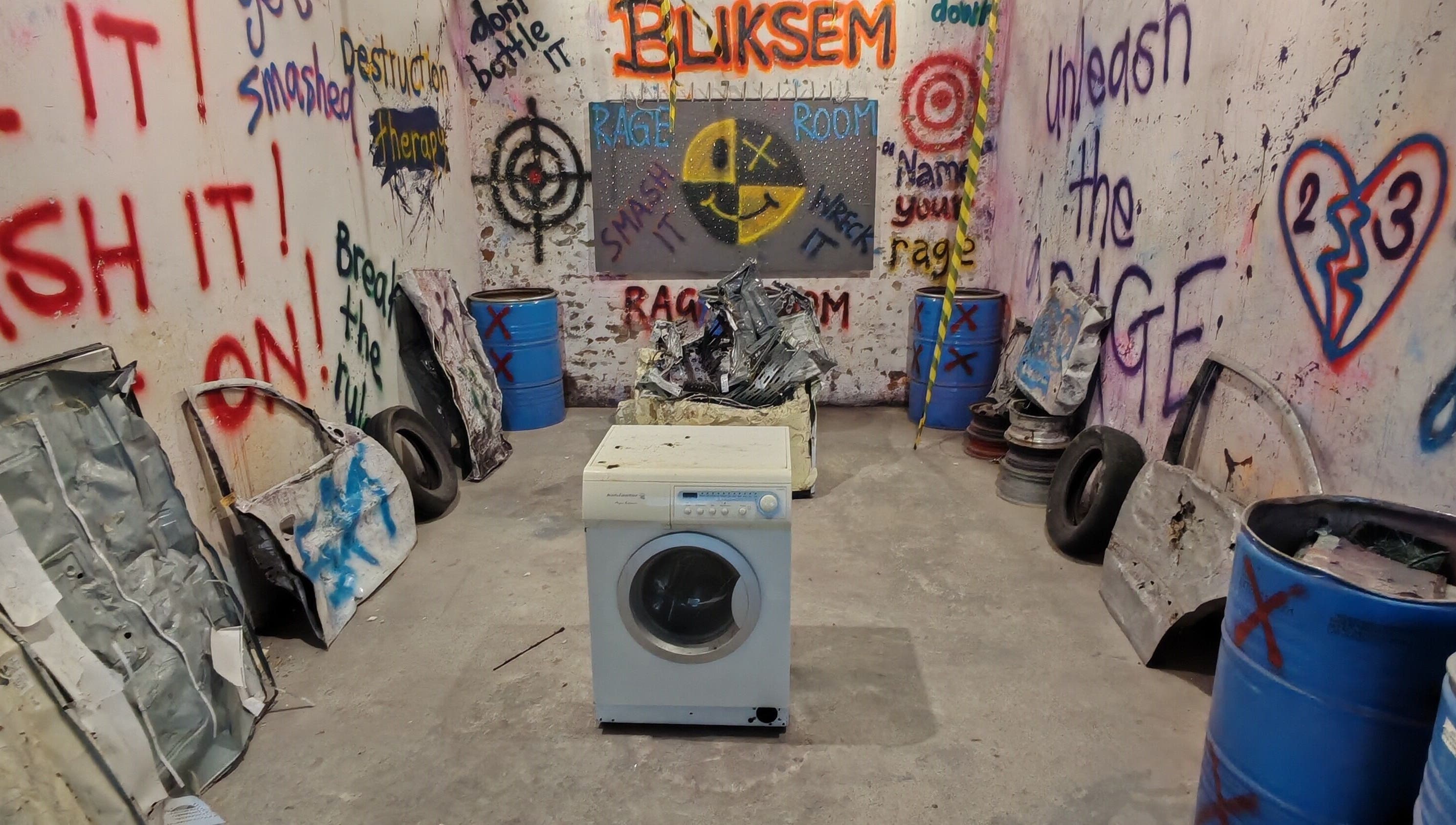 Interior of Bliksem Rage Room in Gqeberha, Eastern Cape, ZA with graffiti walls and smashable items.