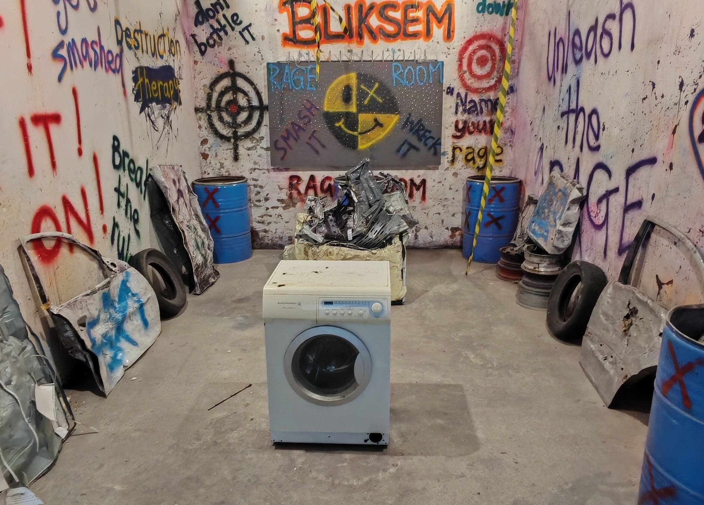 Interior of Bliksem Rage Room in Gqeberha, Eastern Cape, ZA with graffiti walls and smashable items.
