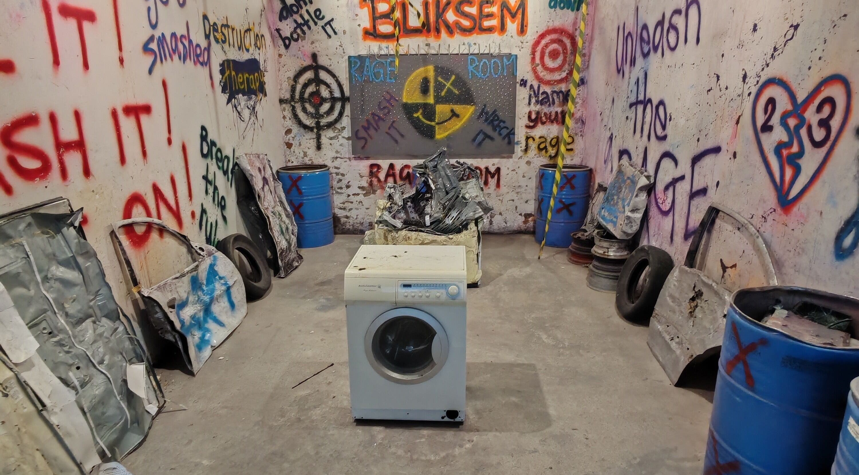 Interior of Bliksem Rage Room in Gqeberha, Eastern Cape, ZA with graffiti walls and smashable items.