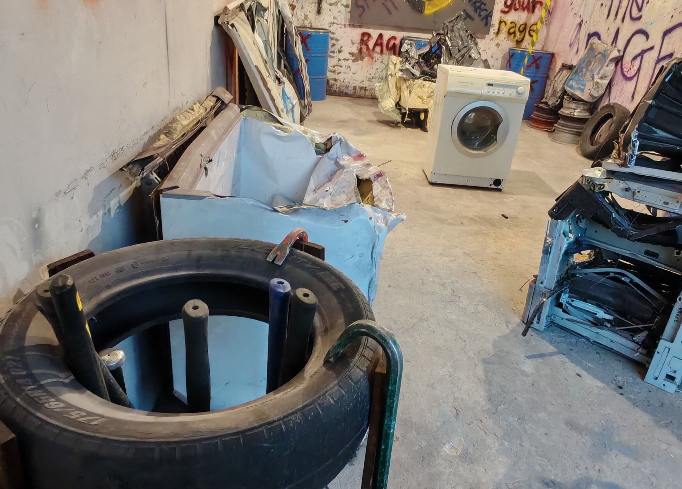 Bliksem Rage Room, Gqeberha, Eastern Cape, ZA, includes tires, appliances, and graffiti for stress relief.