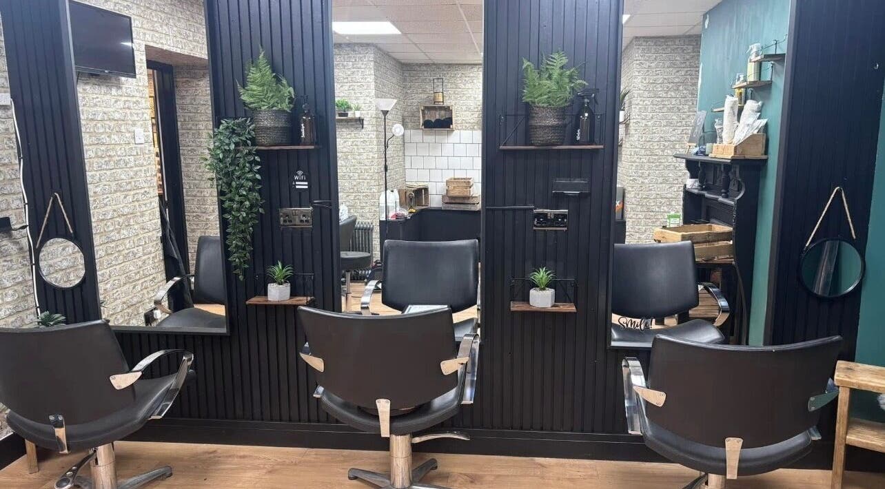 Modern salon interior at Hairbyrose in Ludgershall, England, GB featuring stylish chairs and sleek decor.