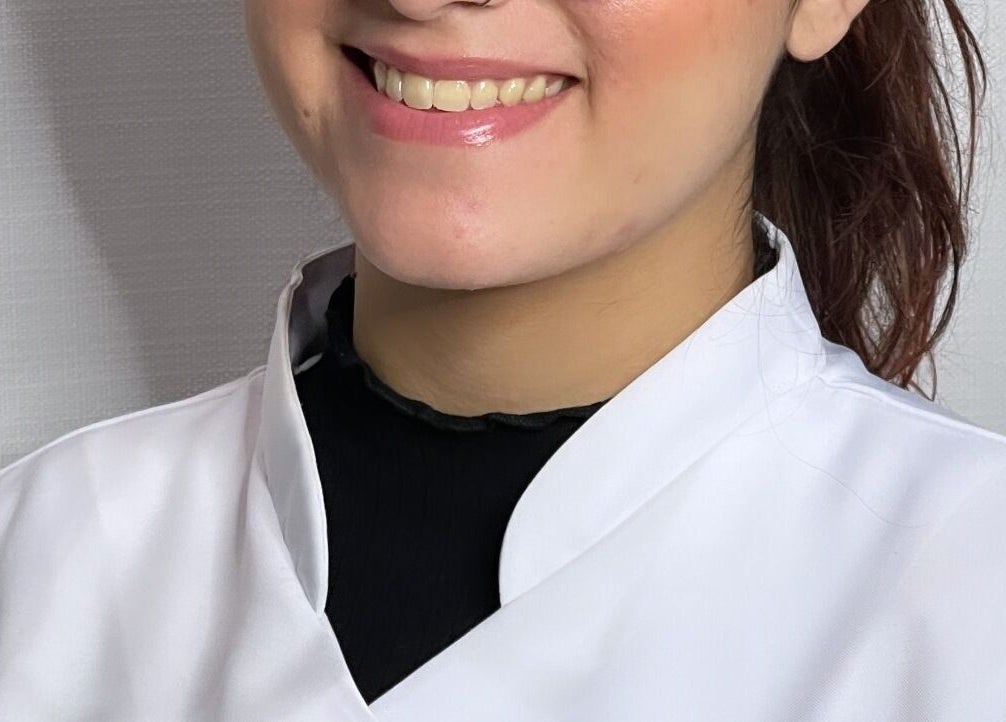 Technicienne de Nails by Mariana Silva à Ettelbruck, Diekirch, LU, souriant chaleureusement en blouse blanche.