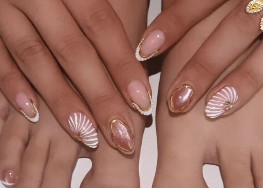 Elegante diseño de uñas en Loto Nails Art, Sabaneta, Antioquia, CO, con detalles dorados y tonos rosados.