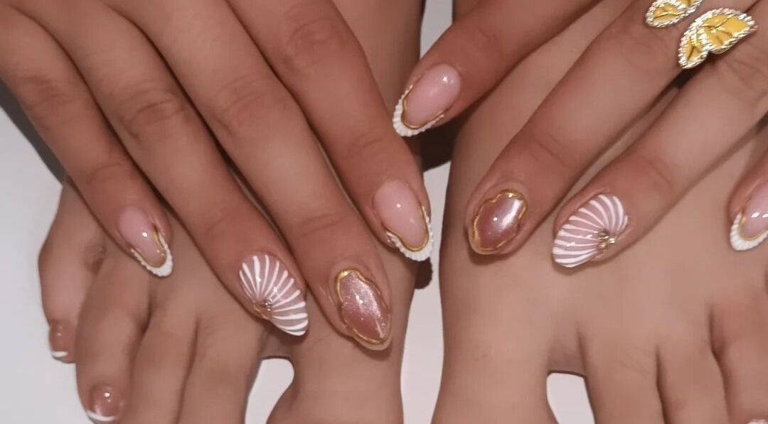 Elegante diseño de uñas en Loto Nails Art, Sabaneta, Antioquia, CO, con detalles dorados y tonos rosados.