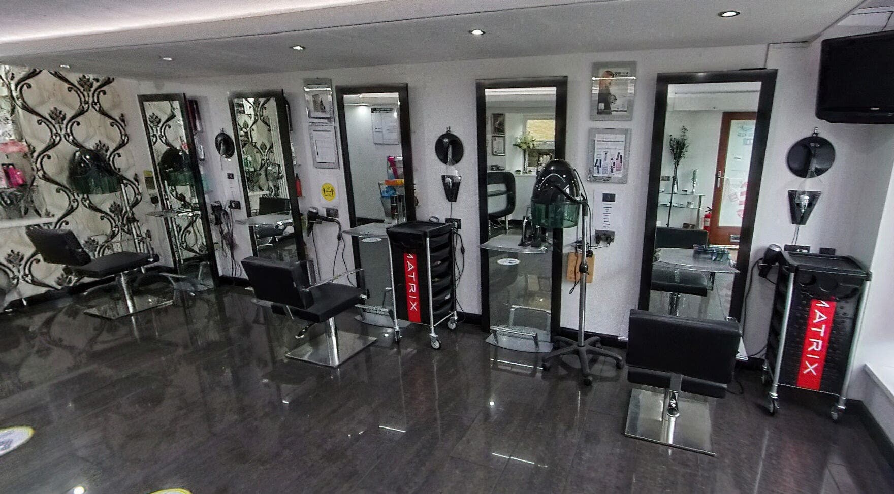 Elegant salon interior of West End Cuts Ltd in Ammanford, Wales, GB with modern styling chairs and mirrors.