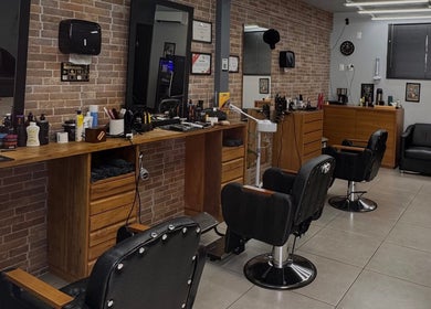 Interior da Modellare Barbershop, Santa Catarina, BR, com cadeiras de barbeiro e espelhos elegantes.