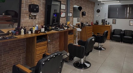 Interior da Modellare Barbershop, Santa Catarina, BR, com cadeiras de barbeiro e espelhos elegantes.