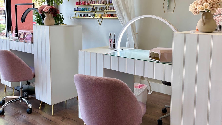Elegant nail station at Blushed Miami, Palmetto Bay, FL, US, showcasing pink chairs and nail polish display.