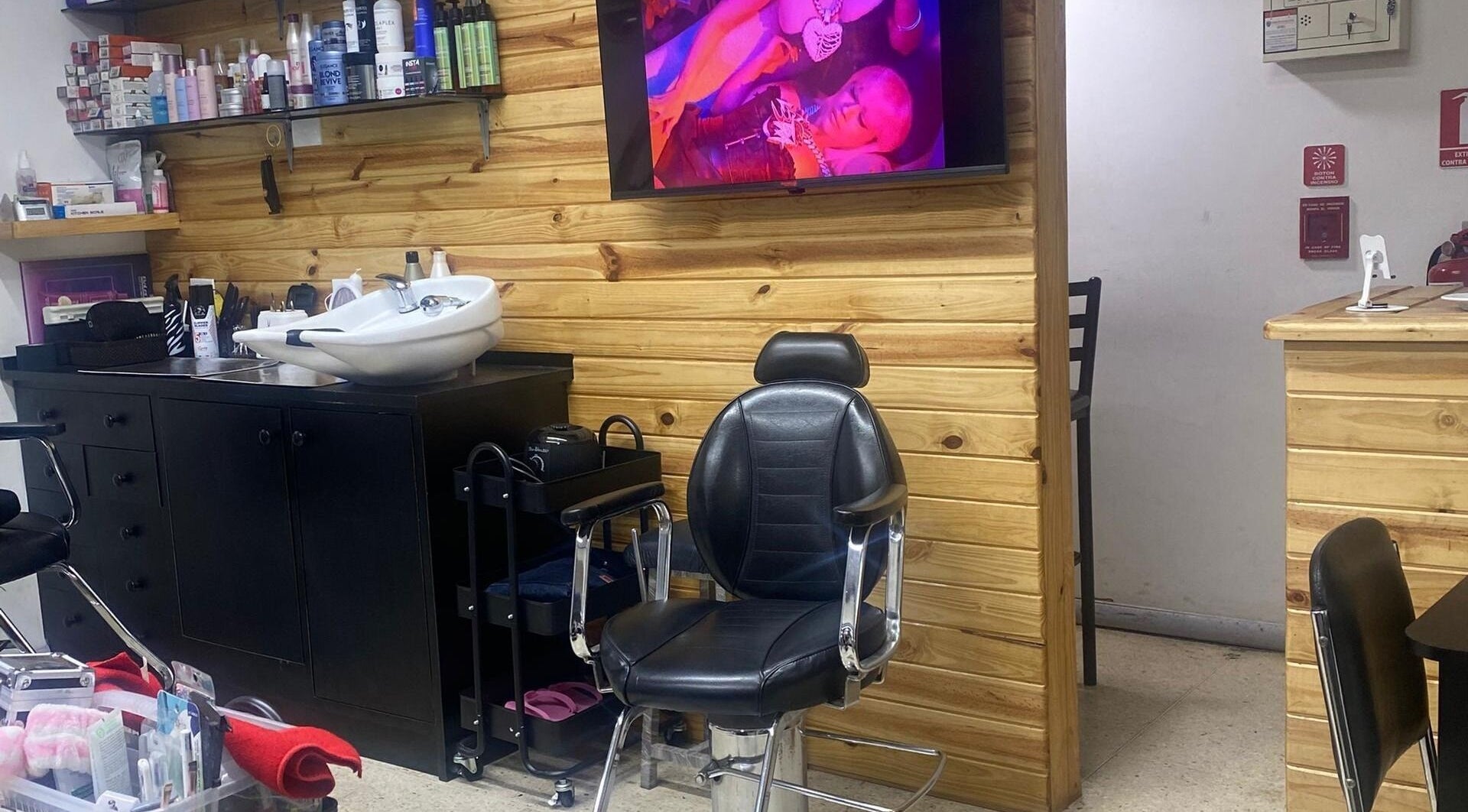 Interior moderno de Jemmas Hair Salon en Caracas, Miranda, VE, mostrando un sillón de peluquería y productos de belleza.