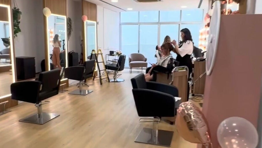 Interior moderno do salão Domenica Nails em Braga, PT com cadeiras de salão e espelhos iluminados.