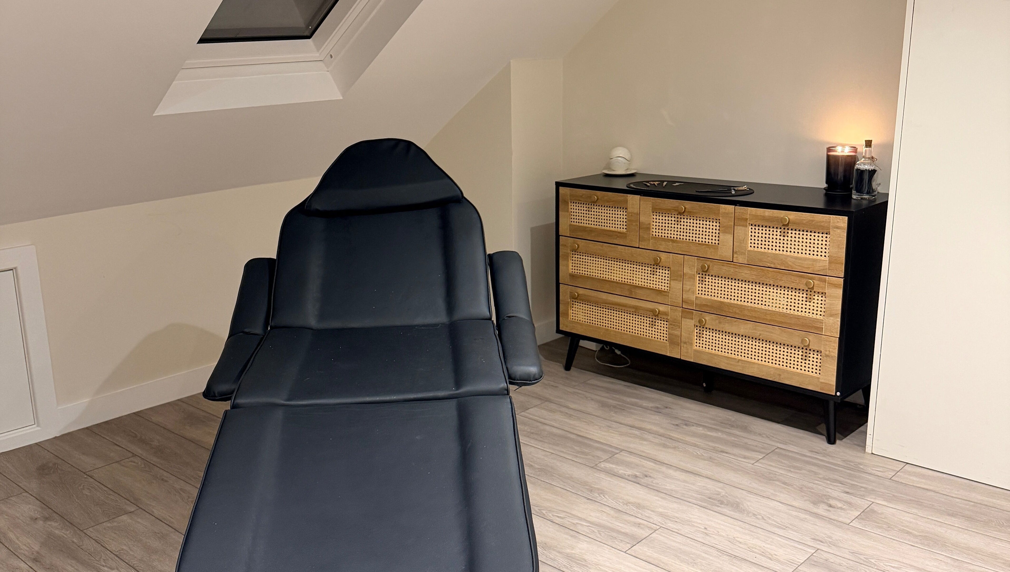Sophisticated treatment room at Brows by GG, Bristol, England, GB with modern chair and wicker dresser.