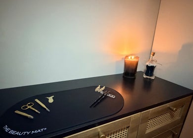 Modern beauty tools and lit candle on a chic dresser at Brows by GG, Bristol, England, GB.